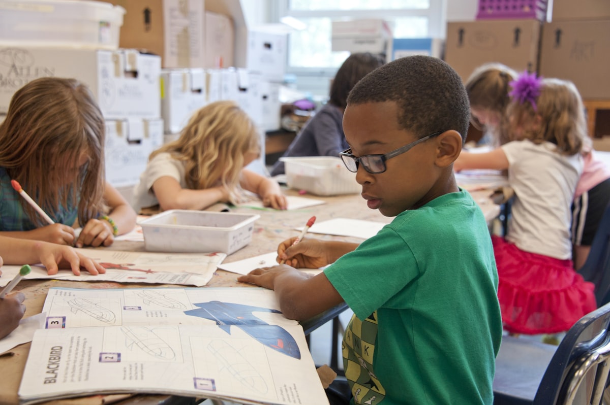 An elementary-aged student working at a classroom desk